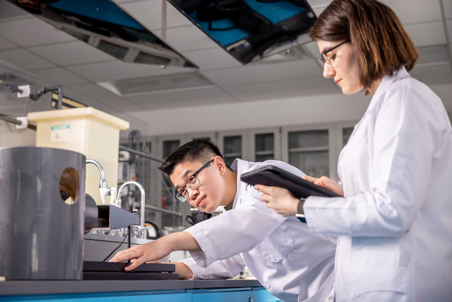 Woman in a lab coat standing in a lab.