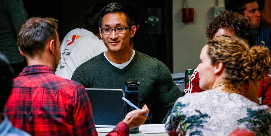 Graduate students sitting at a table and talking