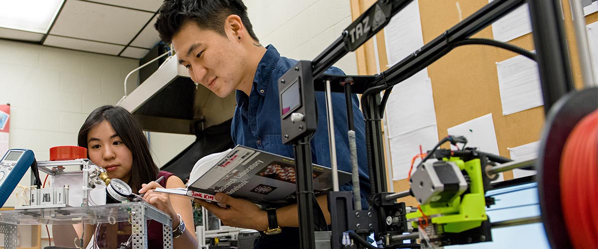 Professor and Biomedical Engineering graduate students in engineering lab