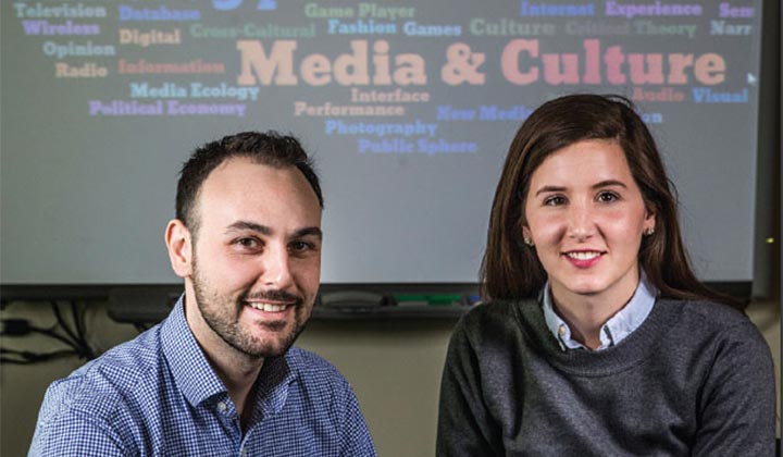 Two graduate students working on a computer in a media lab