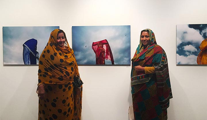 Two women stood in front of a canvas mural on a wall