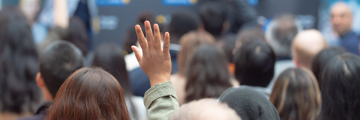 a woman with hand raised in a crowd