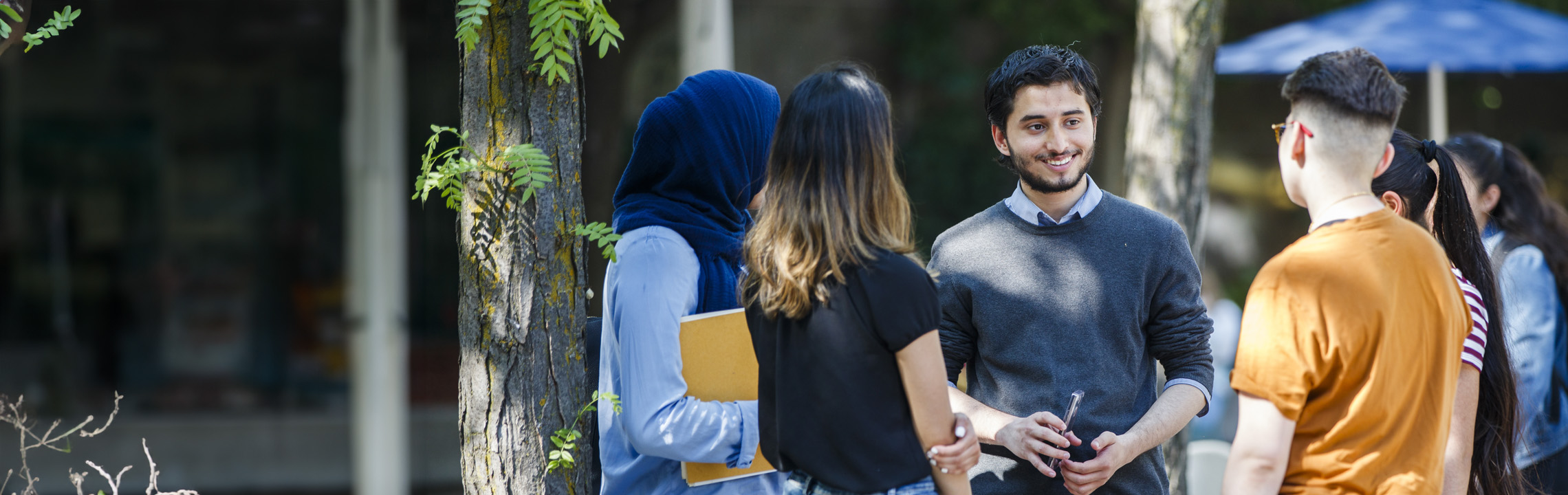 A group of students outside of the Image Arts Centre talking amongst each other.