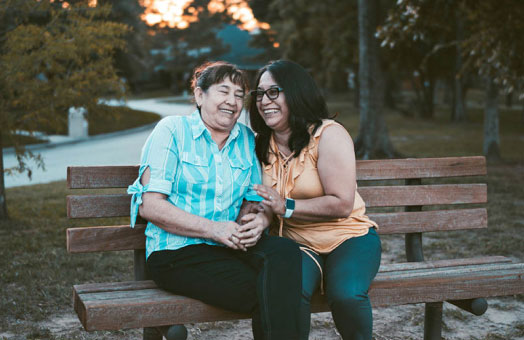 two elderly women sitting on a park bench