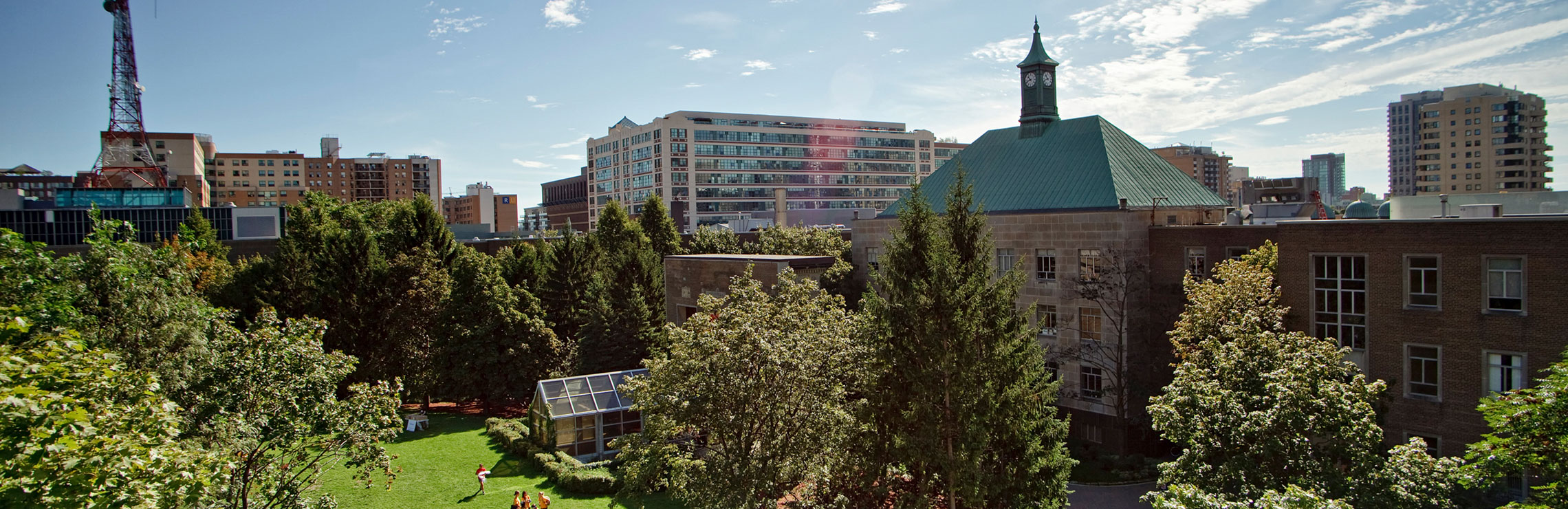 A view of TMU's Quad with green trees and grass looking south east.