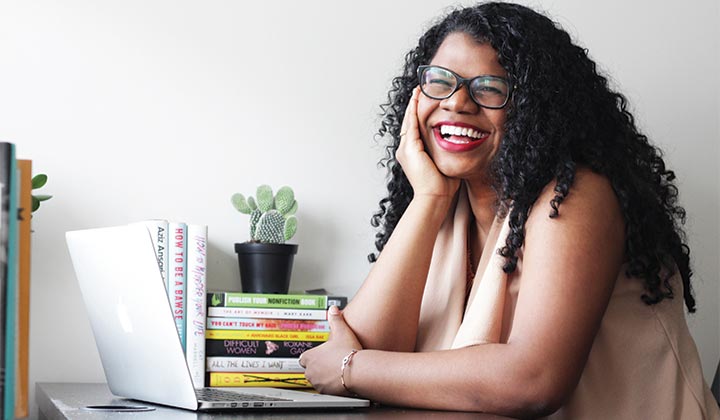 Woman sat at a desk, smiling