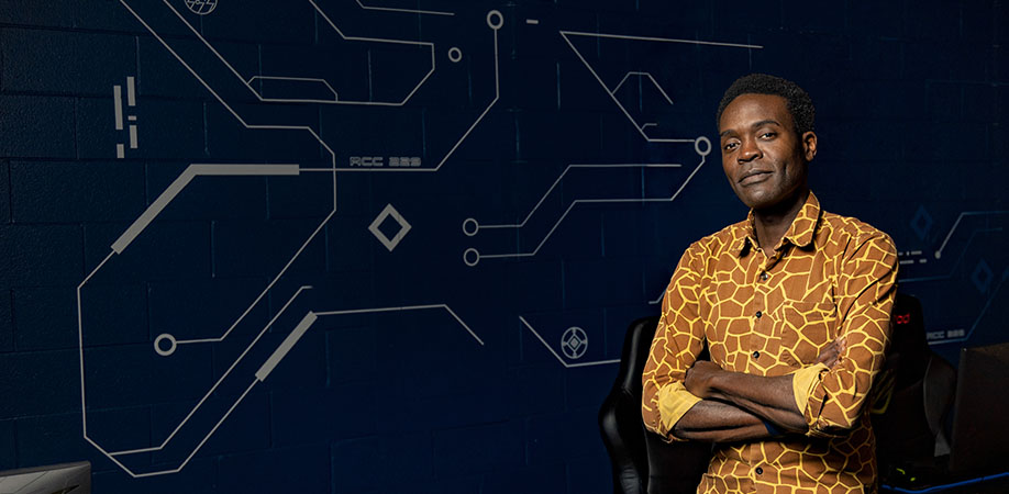 Black man wearing patterned orange and yellow dress shirt