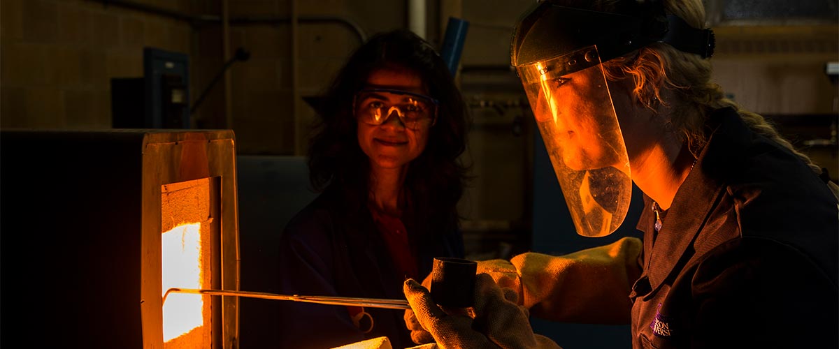 Mechanical Engineering graduate students in lab forging metal in a kiln