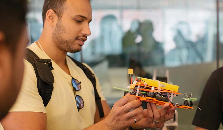 Student examining a robotic drone model