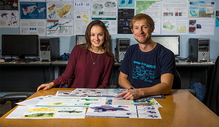 Students sitting at a table working with maps