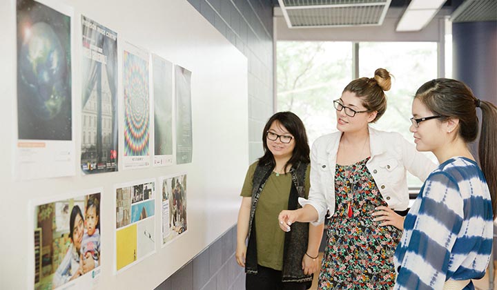 Students looking at a conference poster presentation