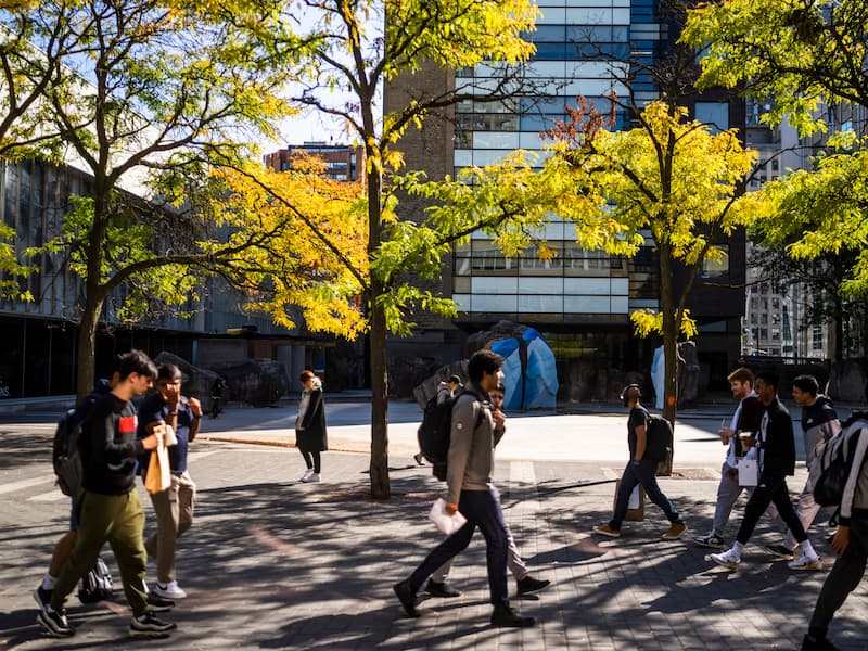 Students walking in both directions along Gould Street in front of Lake Devo