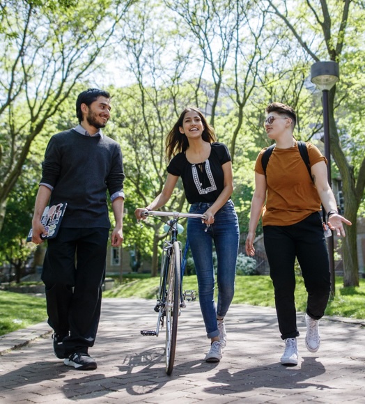 Three students walking in a group through the TMU Quad