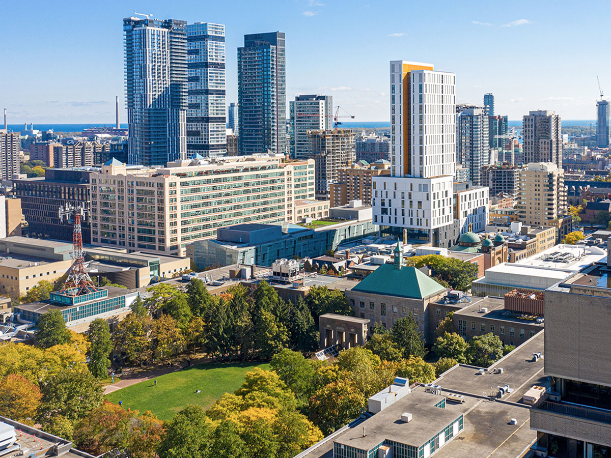 An aerial view of Toronto Metropolitan University’s quad and Student Learning Centre, with tall buildings in downtown Toronto and a blue sky