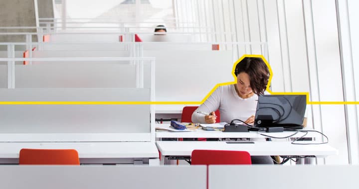 a student sitting at a desk with a laptop