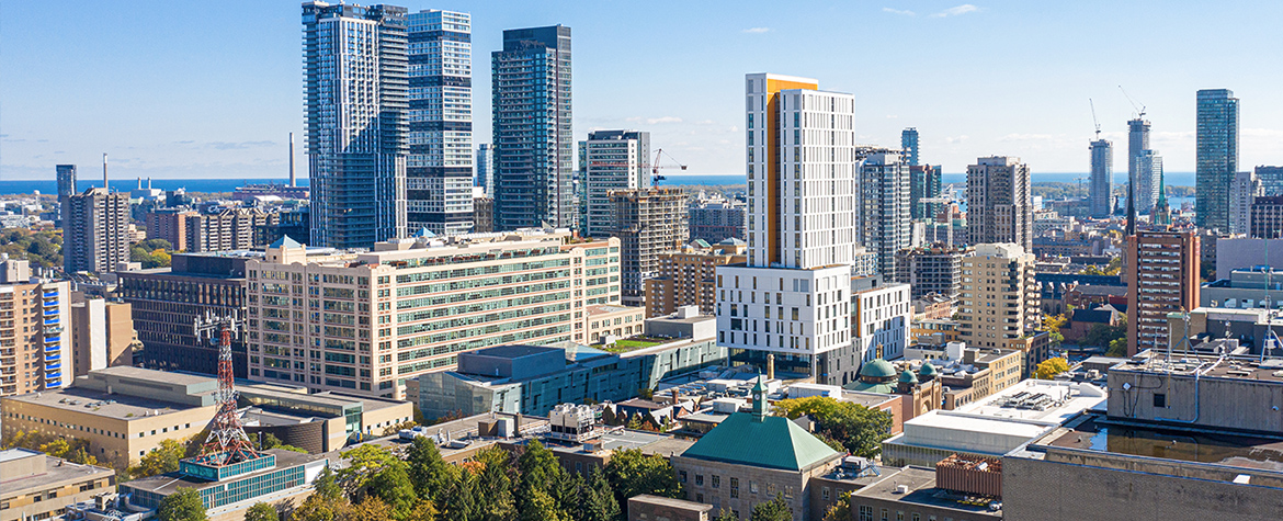 An aerial view of Toronto Metropolitan University’s quad and Student Learning Centre, with tall buildings in downtown Toronto and a blue sky