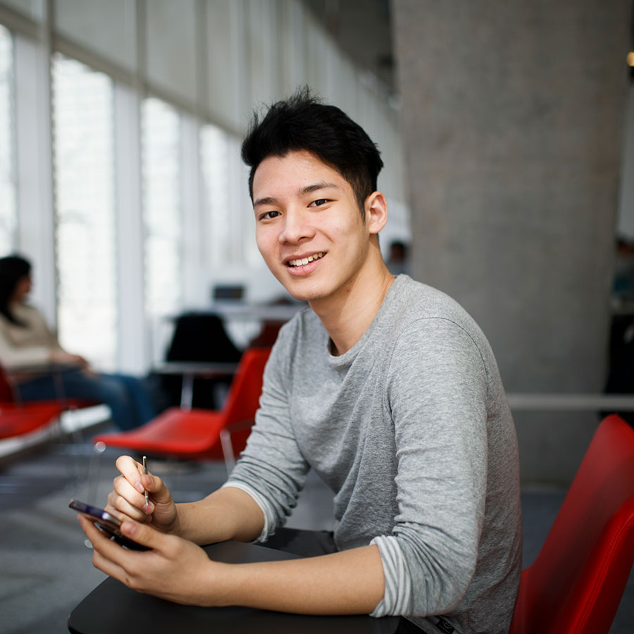 A student smiles at the camera while sitting in the SLC.