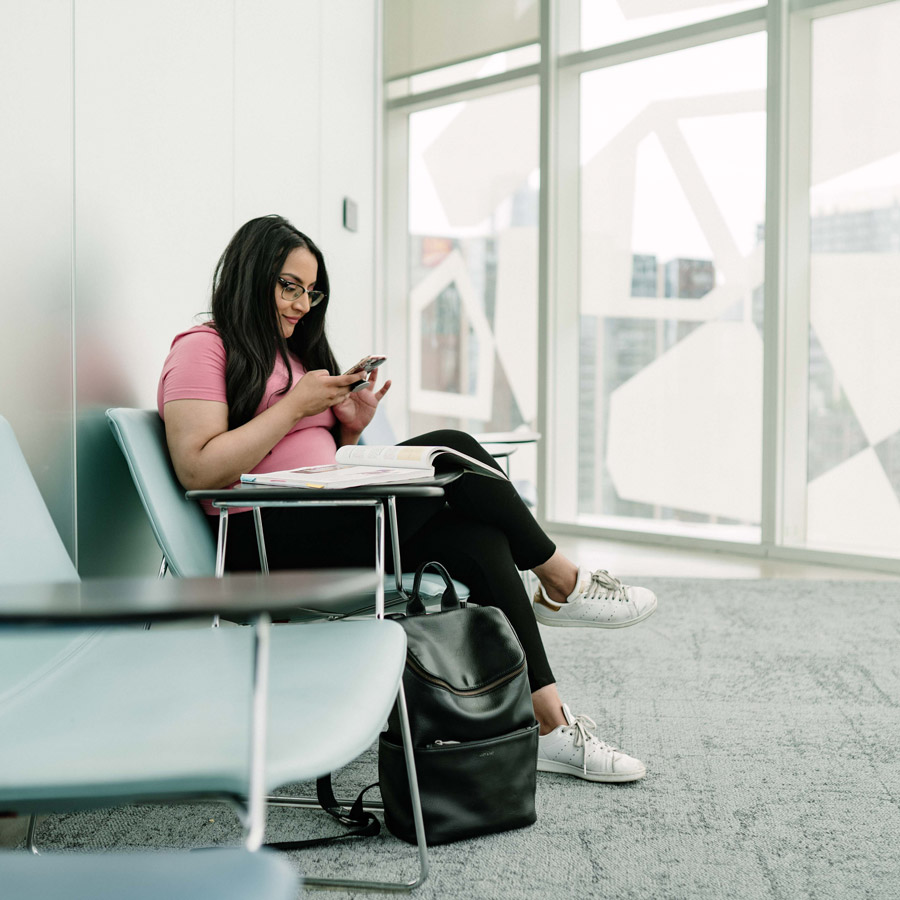 A student smiles as she checks her phone in the SLC.