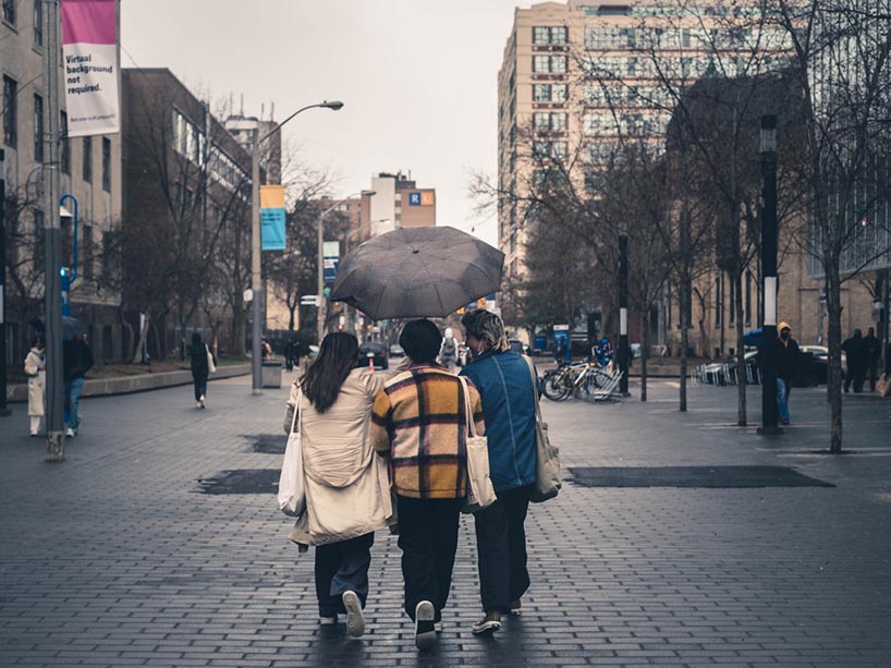 Three students walking on campus together. 